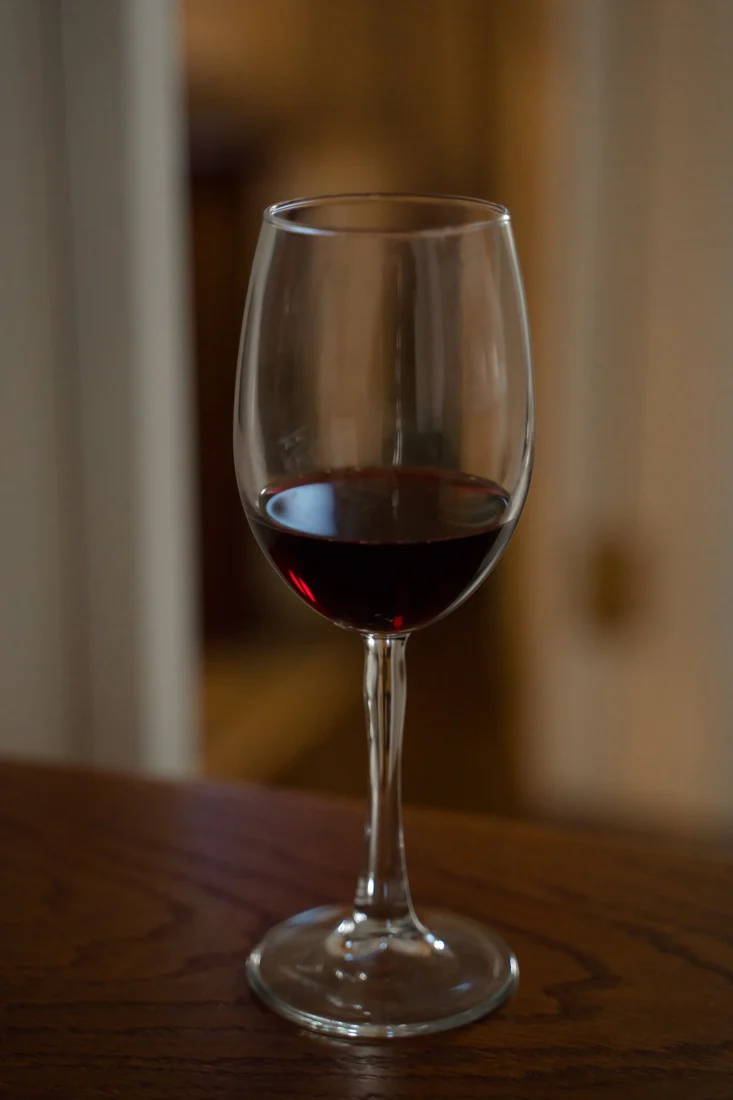 Glas Rotwein auf einem Holztisch